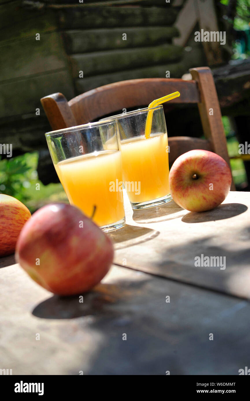 Apples and glasses of apple juice. NOTICE: Authorization for any editorial use respecting the caption and context of the image and not infringing or d Stock Photo