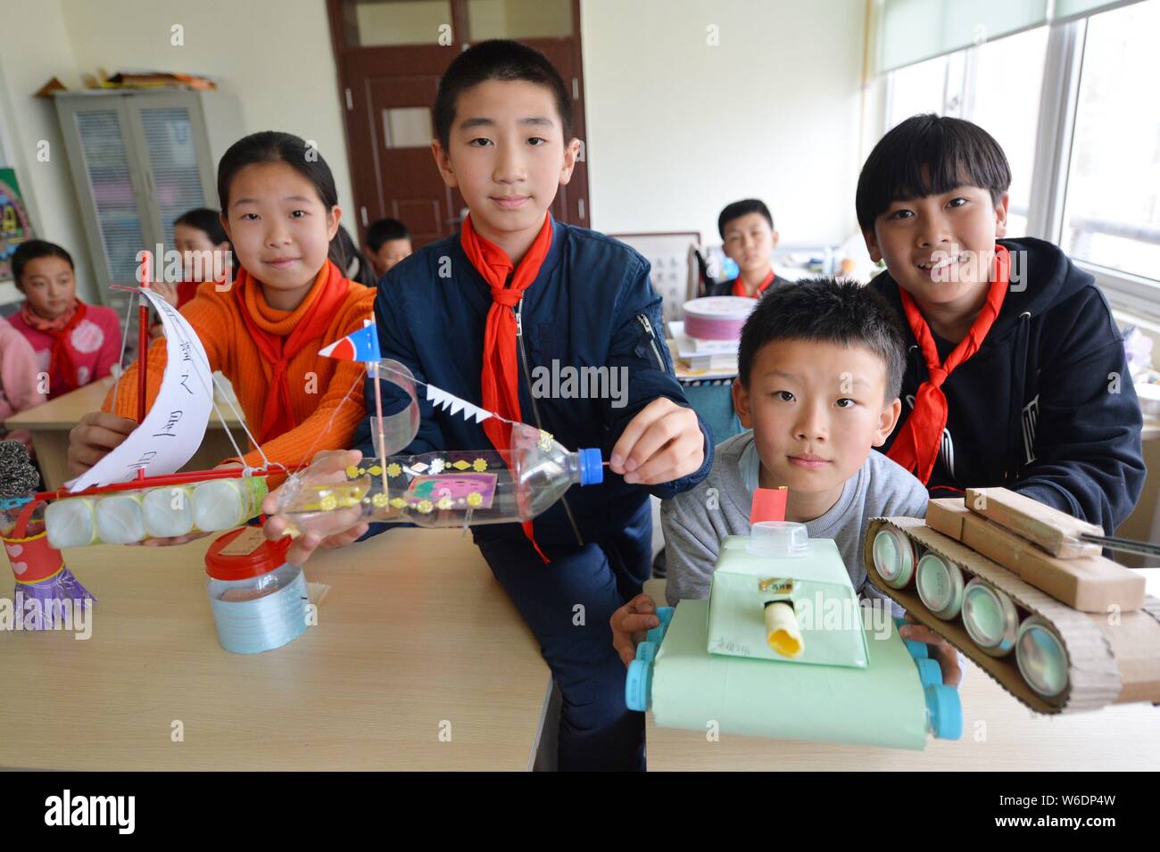 Pupils show handiworks made of wastes at a primary school ahead of the World Earth Day in Qingdao city, east China's Shandong province, 20 April 2018. Stock Photo
