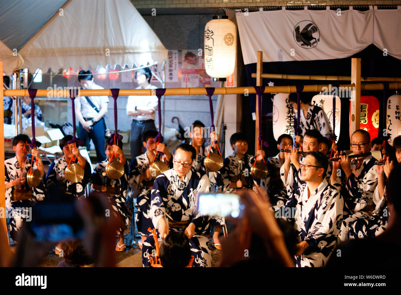 Group of musicians playing traditional japanese flute and bell music in a small festival Stock Photo