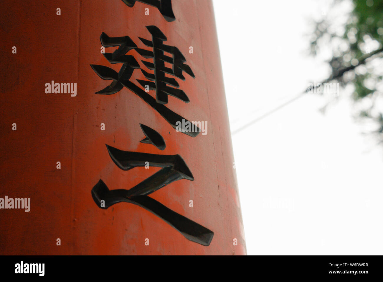 Ancient japanese kanji inscriptions written on a wooden gate with the sky in the background. The two characters are 'Ken' and 'Yuki'. Stock Photo