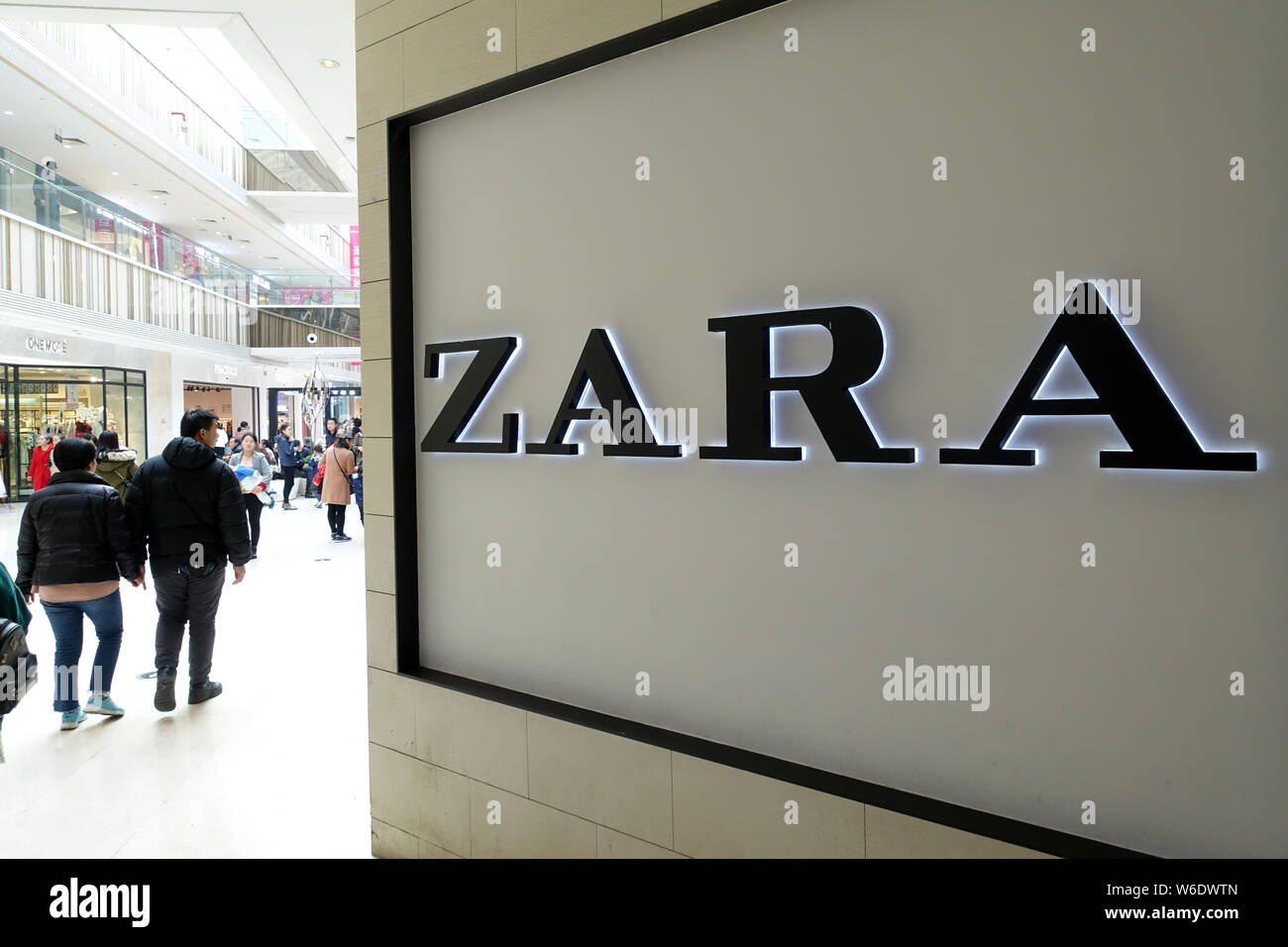 FILE--Pedestrians walk past a signboard of fashion retailer Zara in  Shanghai, China, 9 January 2018. Fashion brand Zara has joined a string of out  Stock Photo - Alamy