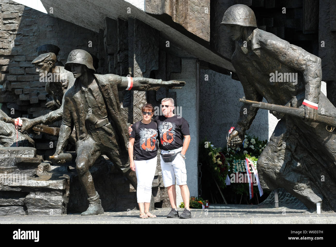 Warsaw Poland - Thursday 1st August - A Polish couple stand proudly in front of the Warsaw Uprising monument in Warsaw as Poland commemorates the 75th Anniversary of the Warsaw Uprising ( Powstanie Warszawskie ) against the occupying German Army on 1st August 1944 - the Warsaw Uprising resistance fighters of the Home Army ( Armia Krajowa  - AK ) struggled on for 63 days against the Nazi forces before capitulation as the advancing Soviet Army waited across the nearby River Vistula. Photo Steven May / Alamy Live News Stock Photo