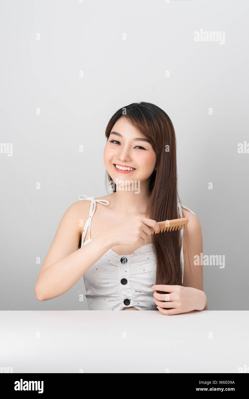 Portrait of a Beautiful Young Asian Female - combing her long straight hair Stock Photo