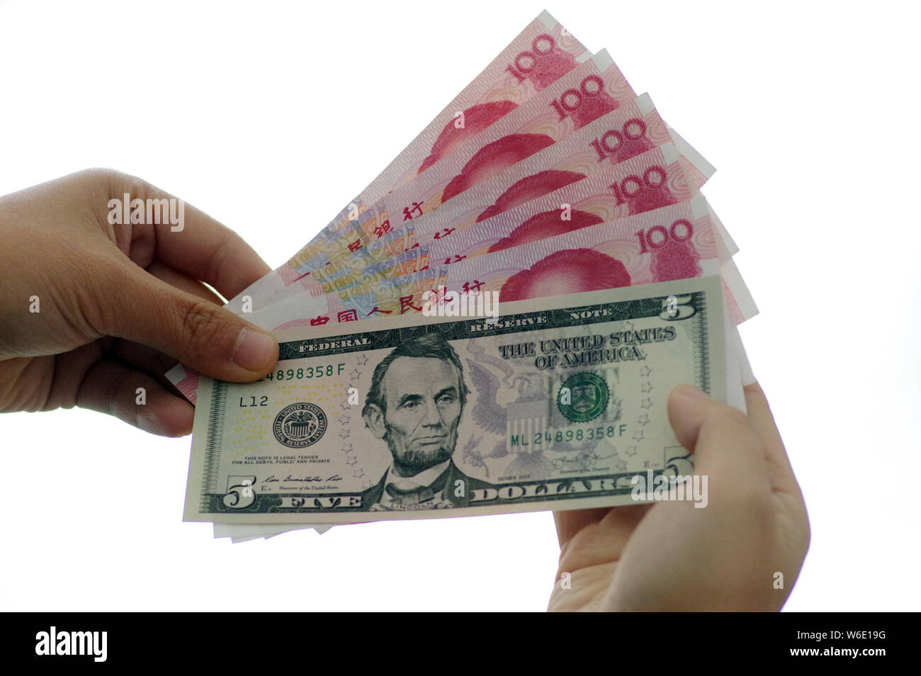--FILE--A Chinese resident shows at RMB (renminbi) yuan bills and a US ...