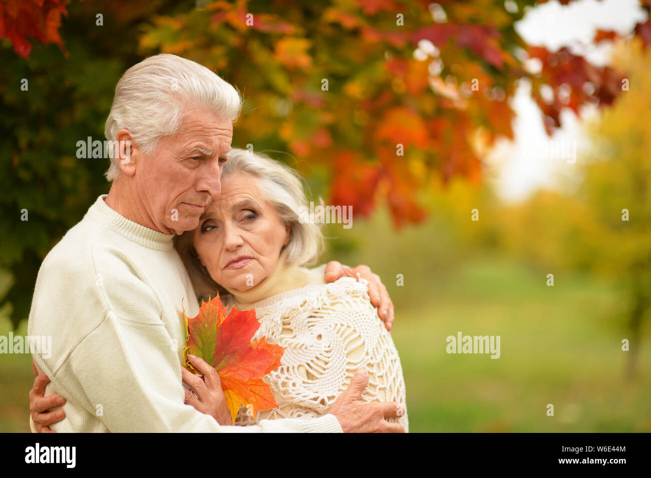 Portrait of sad senior couple in autumn park Stock Photo - Alamy