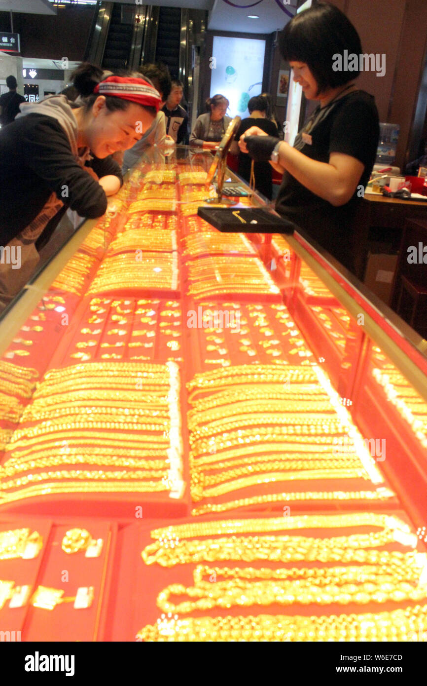 --FILE--Chinese customers shop for gold ornaments at a jewelry store in ...