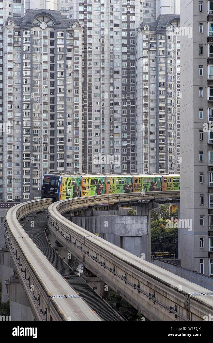 A monorail train of Chongqing Light Rail runs through highrise