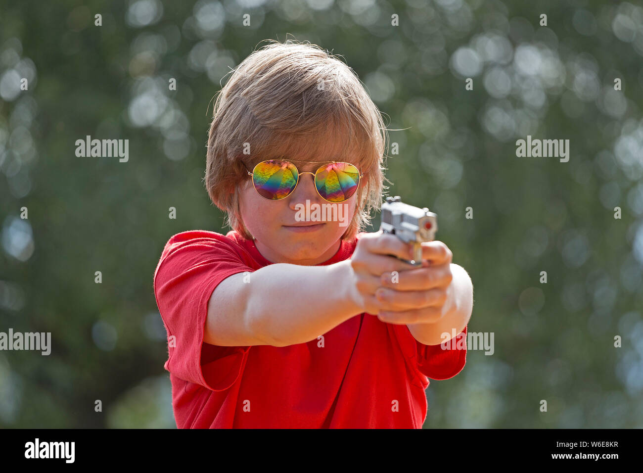 boy aiming with toy pistol, Freiberg, Bayerischer Wald, Bavaria, Germany Stock Photo