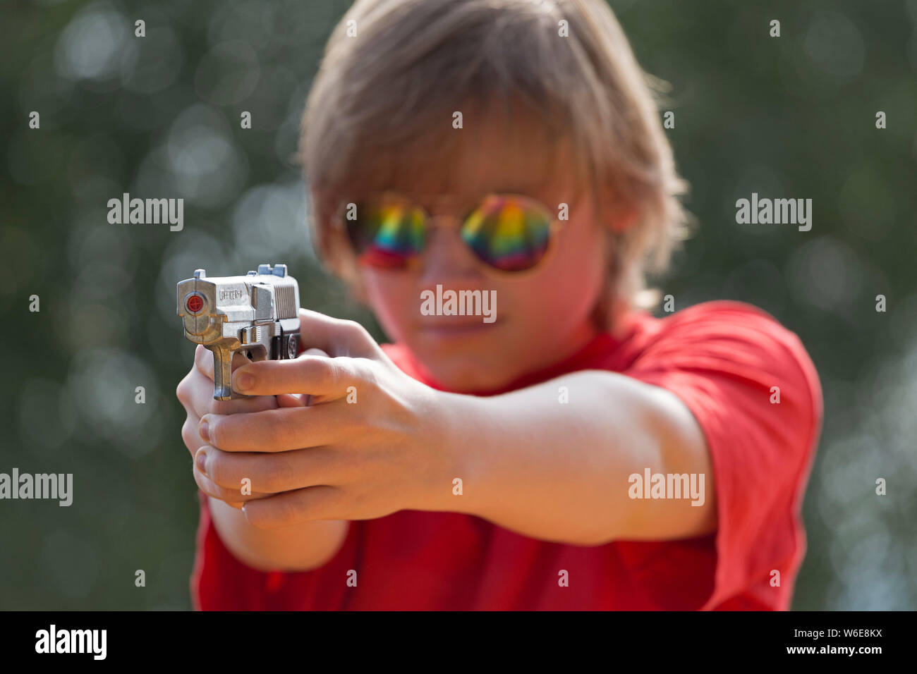 boy aiming with toy pistol, Freiberg, Bayerischer Wald, Bavaria, Germany Stock Photo