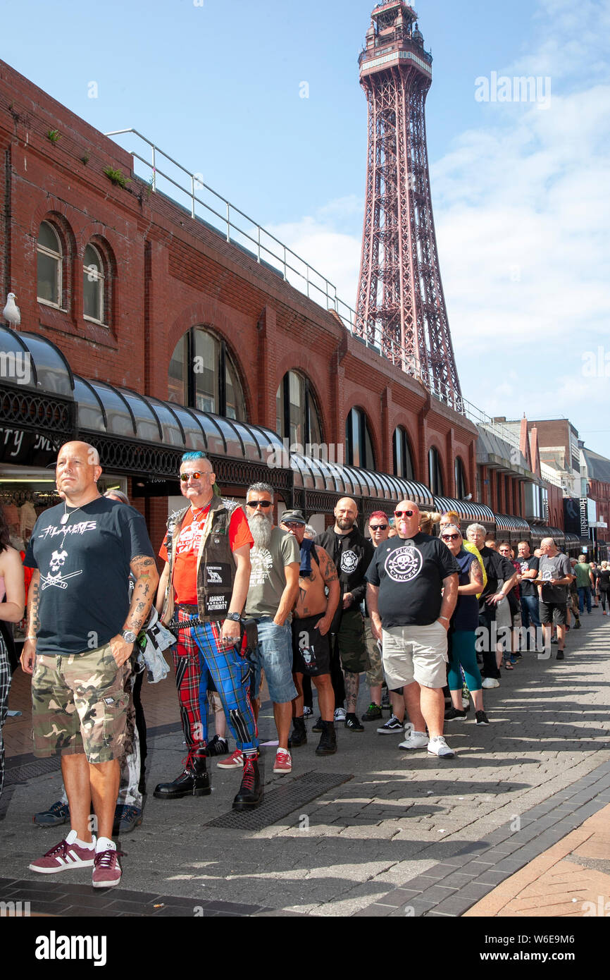 Blackpool, Lancashire, UK. 1st August,  2019.  100s queue for the Rebellion Festival world's largest punk festival in Blackpool. At the beginning of August, Blackpool’s Winter Gardens plays host to a massive line up of punk bands for the 21st edition of Rebellion Festival attracting thousands of tourists to the resort.  Over 4 days every August in Blackpool, the very best in Punk gather for this social event of the year with 4 days of music across 6 stages with masses of bands. Credit; MediaWorldImages/Alamy Live News Stock Photo