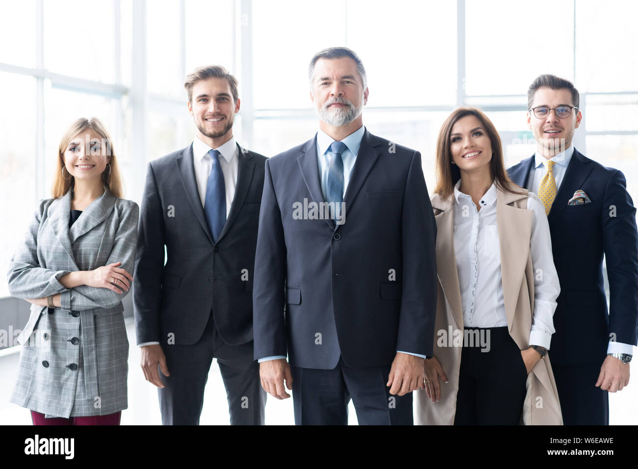 Happy business team with arms crossed at the office Stock Photo - Alamy