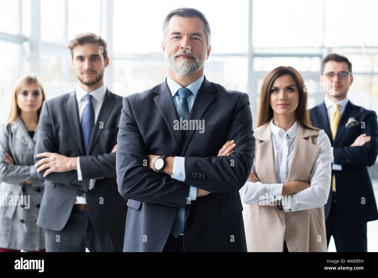 Happy business team with arms crossed at the office Stock Photo - Alamy
