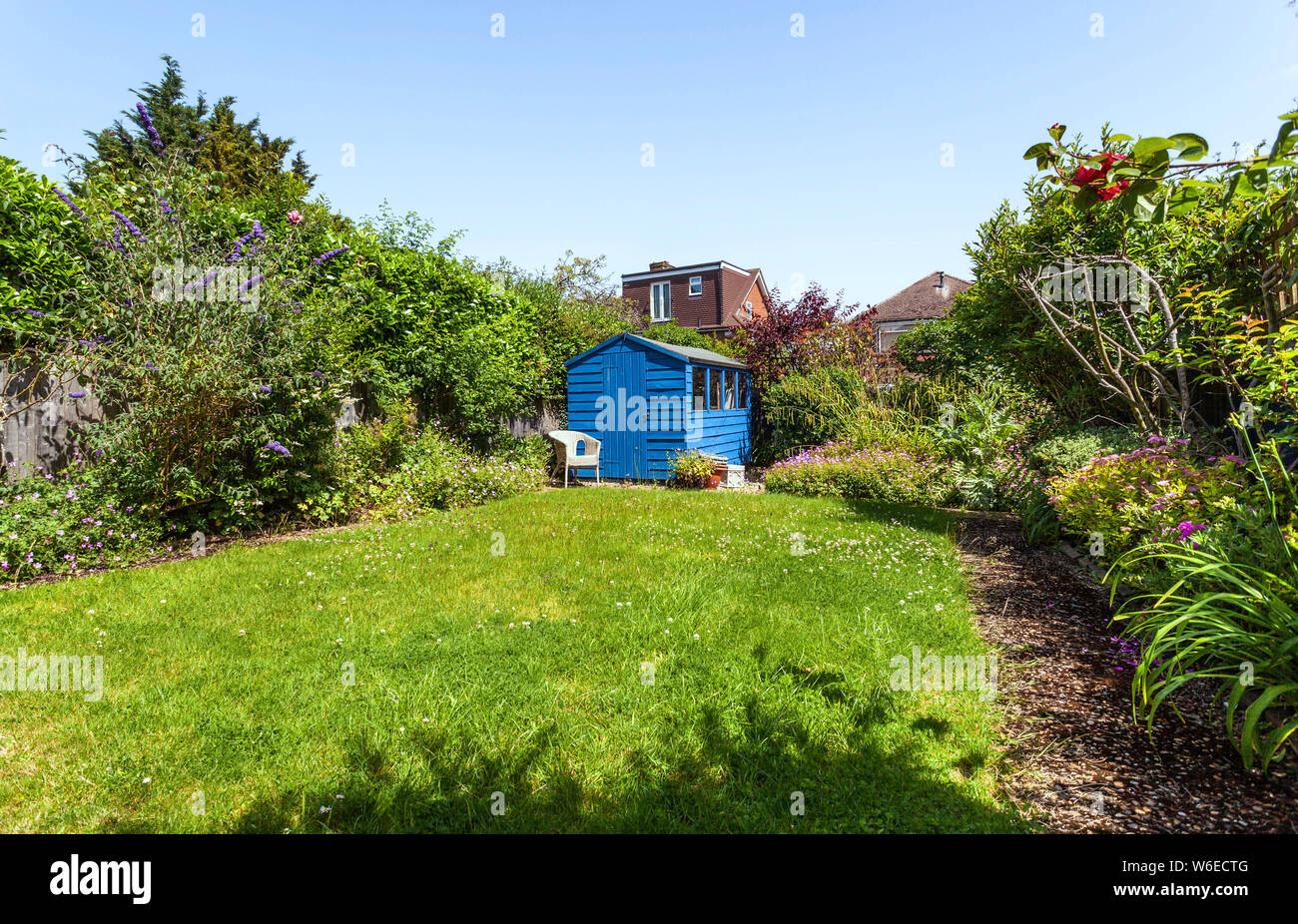 A wooden blue shed situated in a far corner of a back garden, Edgware, Middlesex, England, UK. Stock Photo