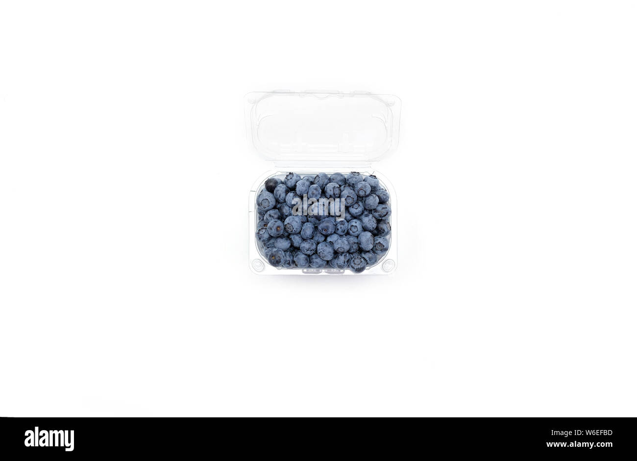 Organic blueberries in the plastic container.Flat lay concept of berries in plastic on white background with copy space in minimal style. Stock Photo