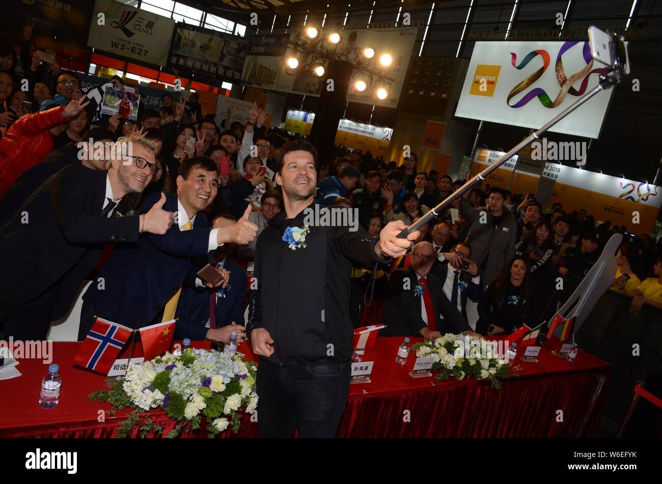 Retired German football player Michael Ballack, front, takes selfies with fans during a press conference for Beamy Booth of Domotex Shanghai exhibitio Stock Photo