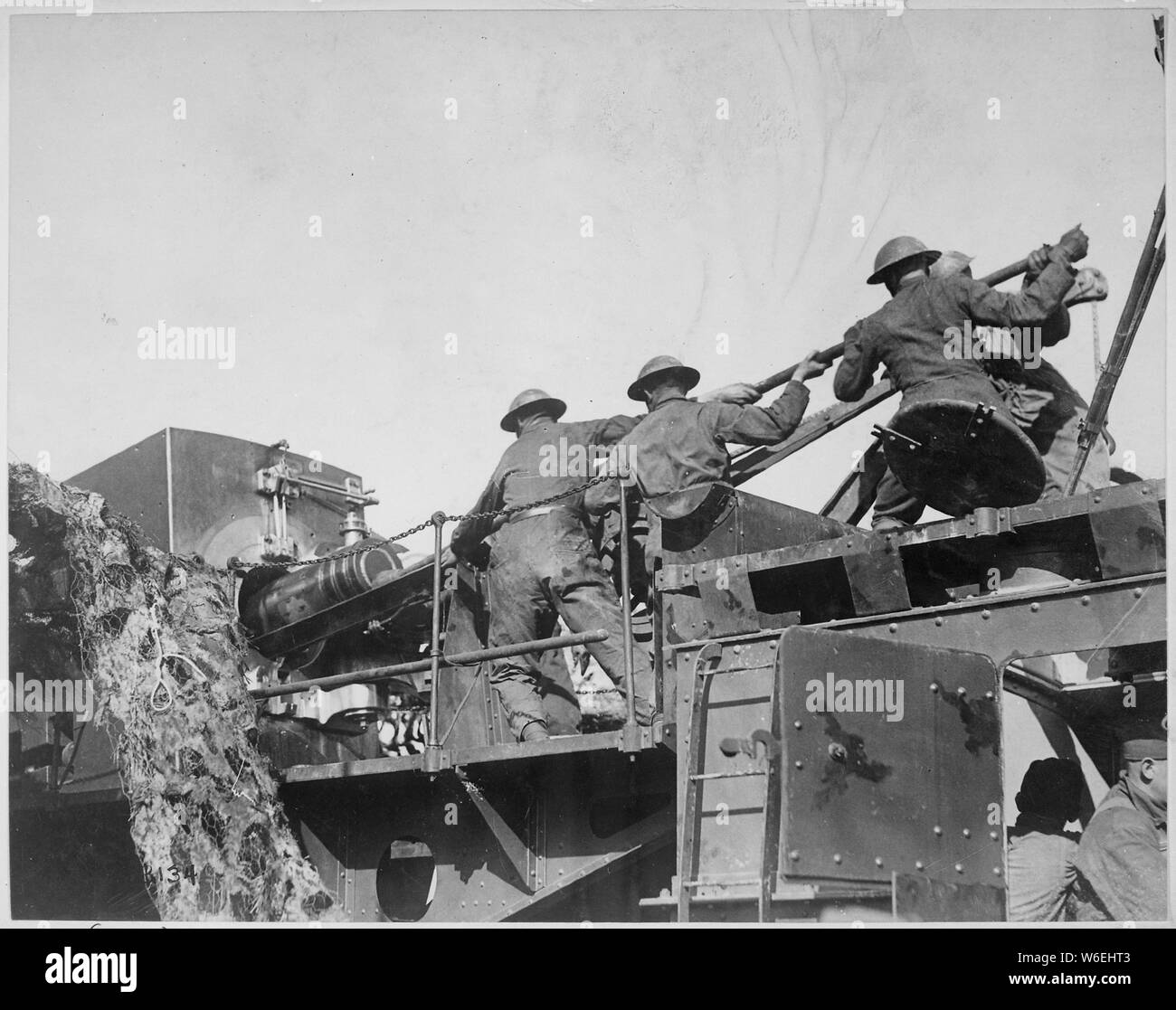 14-inch gun talks for U.S. Men of the 35th Coast Artillery loading a mobile railroad gun, 13.9 inches calibre, on the Argonne front. Baleycourt, France., 09/26/1918 NOTE: This shows the Mk II 14 inch gun car, which had no armoured crew house over the breech. Mk II was a postwar implementation, hence the National Archives caption cannot be correct. The wartime crews were exclusively Navy. This is probably a postwar training photograph, showing coastal defence activity.; General notes:  Use War and Conflict Number 625 when ordering a reproduction or requesting information about this image. Stock Photo