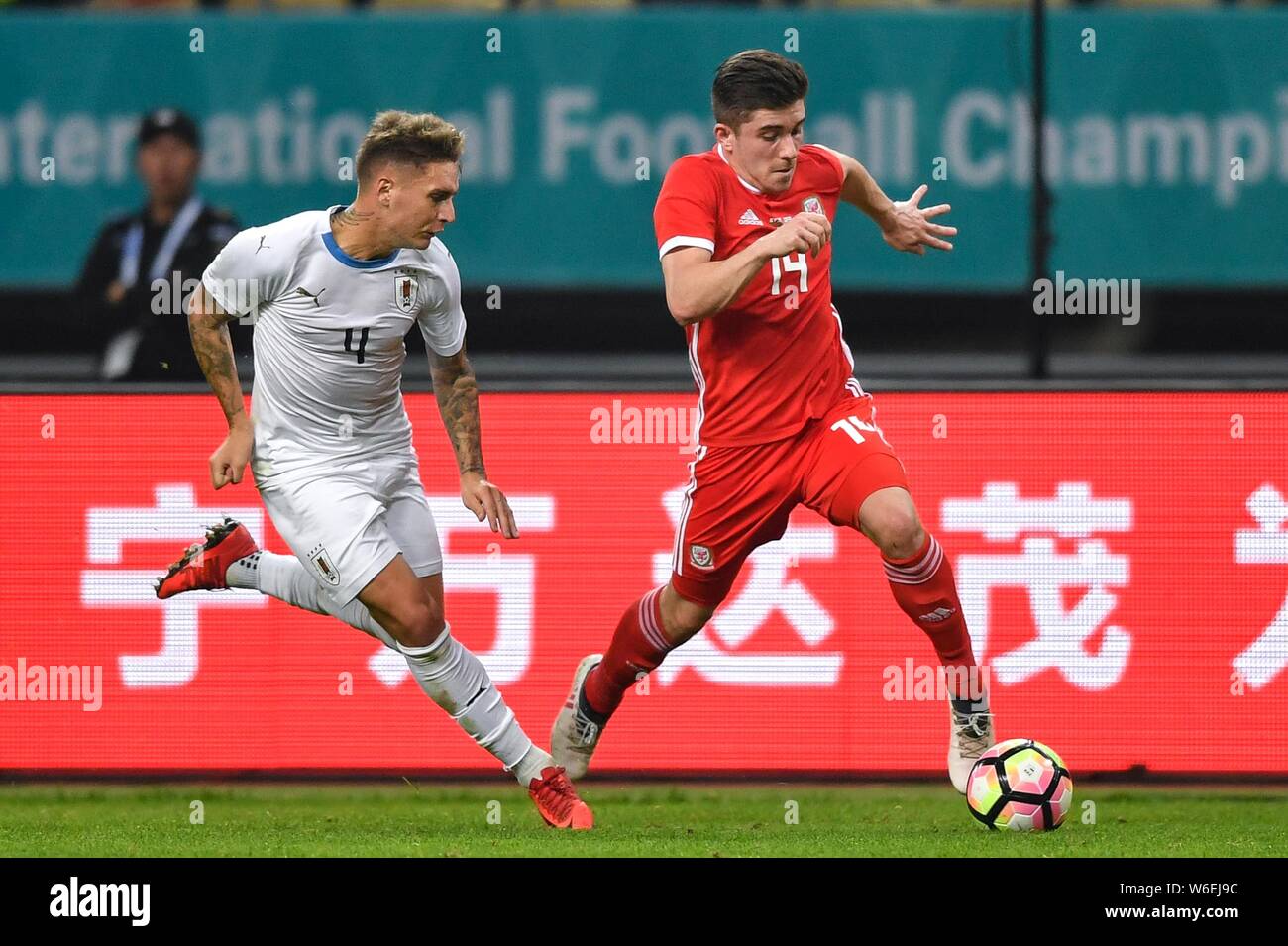 Declan John, right, of Wales national football team kicks the ball to make a pass against Guillermo Varela of Uruguay national football team in their Stock Photo