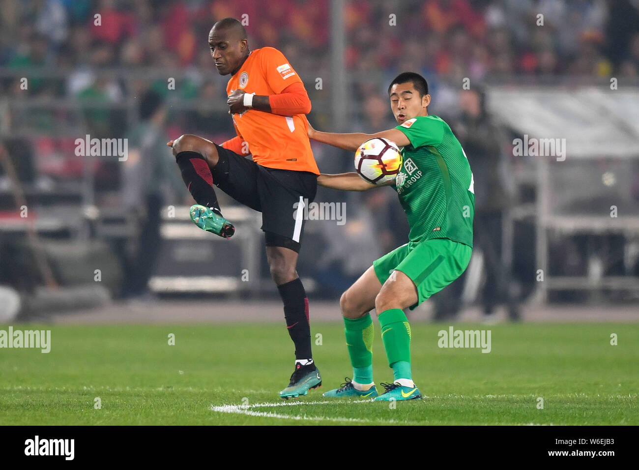 Ecuadorian football player Jaime Ayovi of Beijing Renhe, left, challenges Zhang Yu of Beijing Sinobo Guoan in their fourth round match during the 2018 Stock Photo