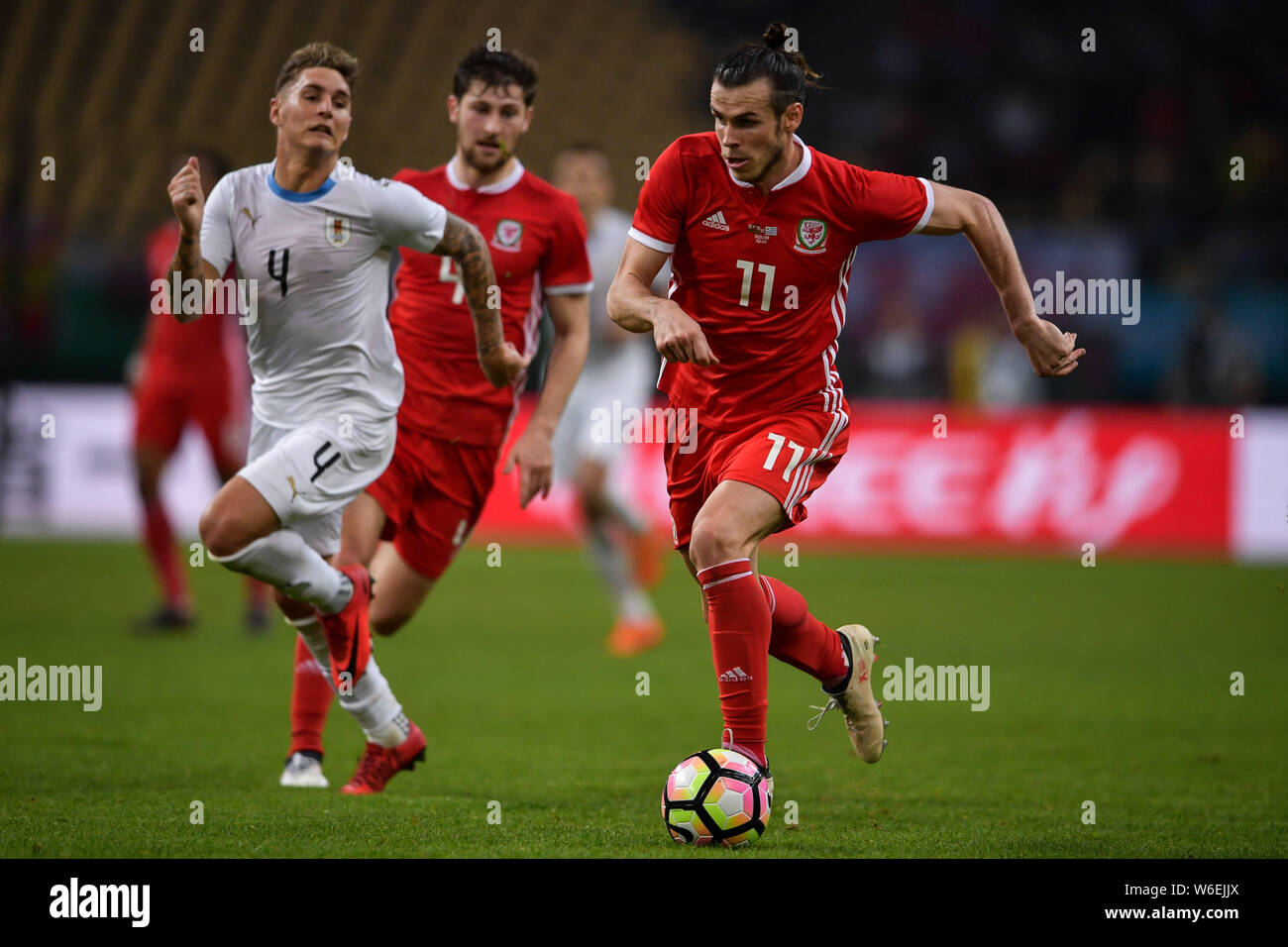 Gareth Bale, right, of Wales national football team kicks the ball to make a pass against Guillermo Varela of Uruguay national football team in their Stock Photo