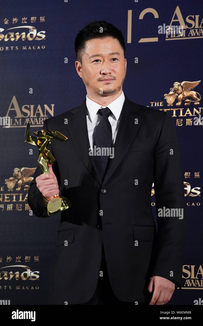 Chinese actor and director Wu Jing or Jacky Wu poses with his trophy