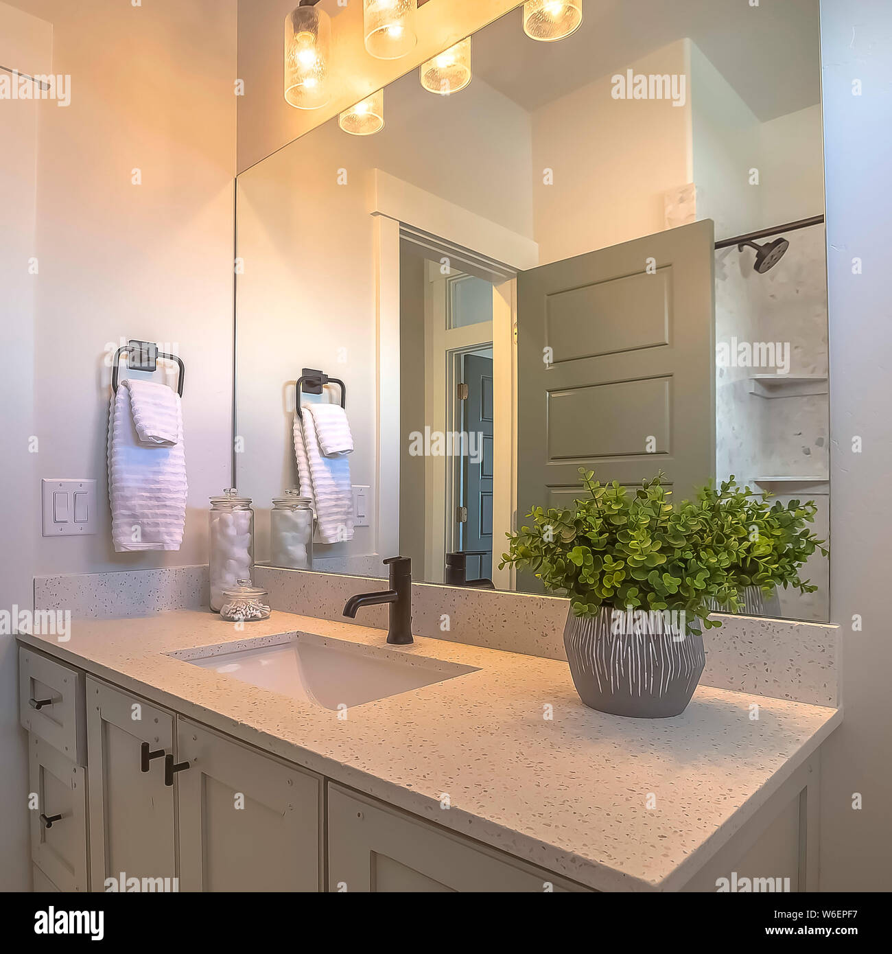 Square Mirror And Vanity Unit Inside A Bathroom With White Wall And Brown Wood Floor Stock Photo Alamy