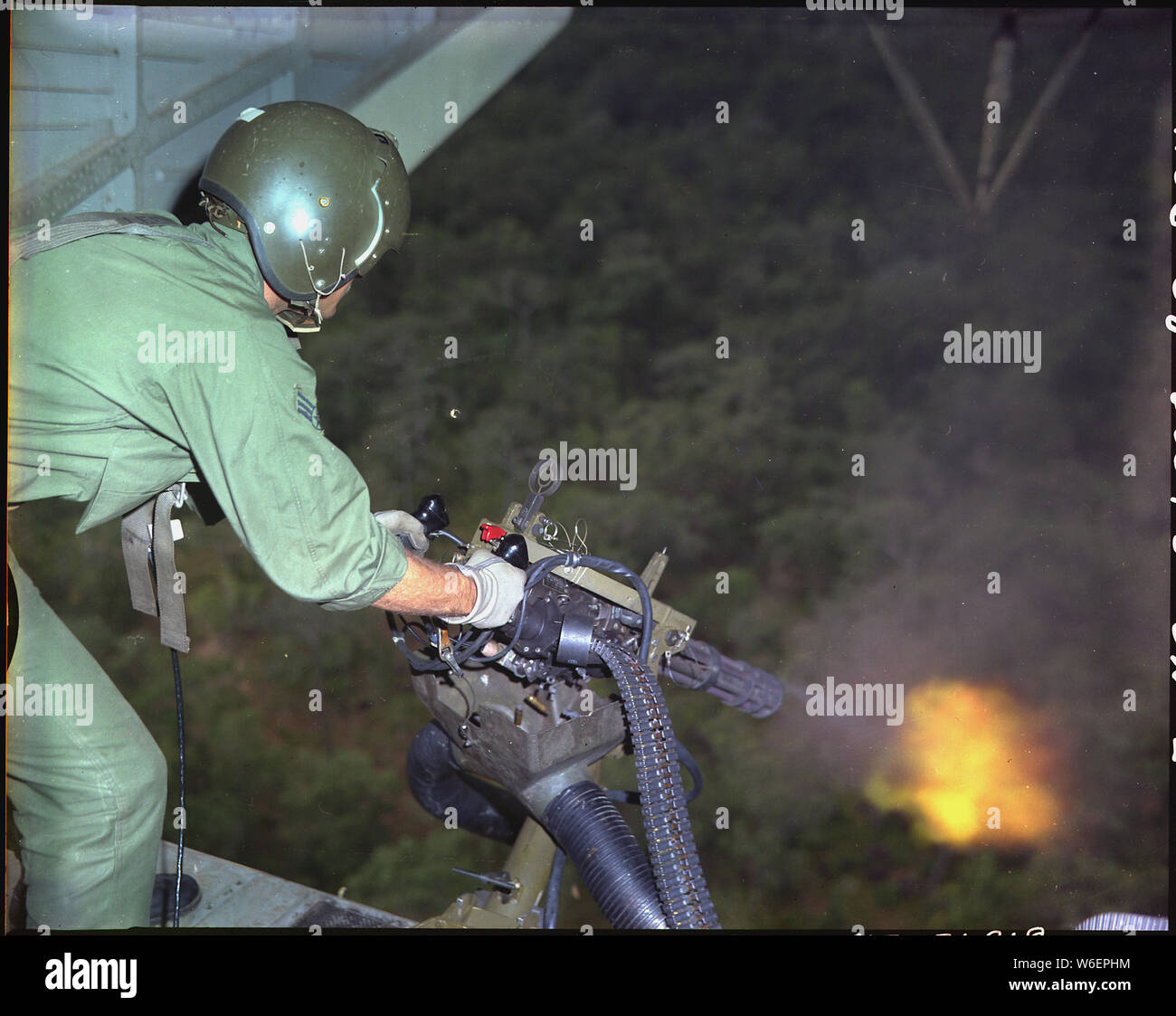 English A U.S. Air Force HH3 helicopter crewman fires a minigun