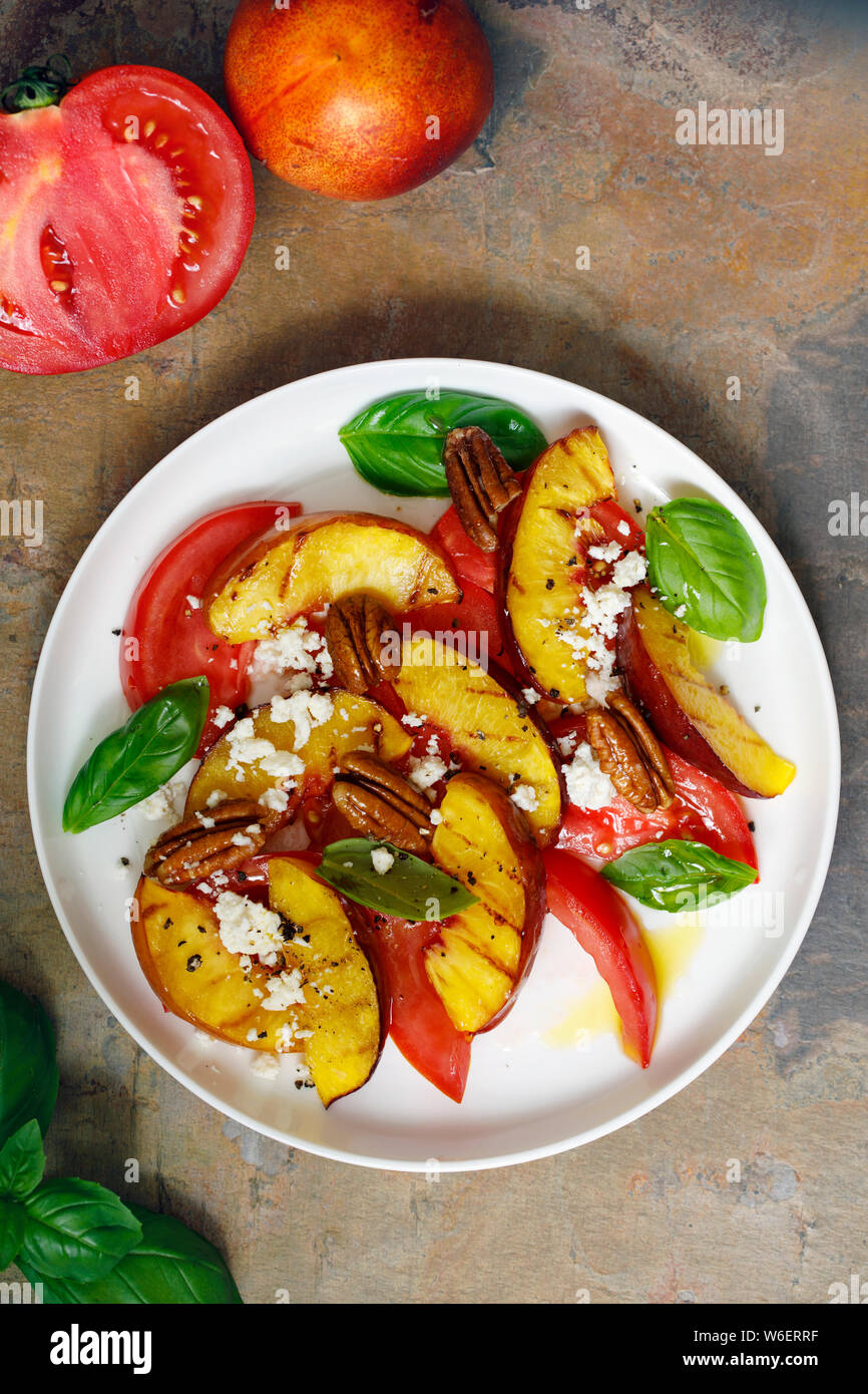 Grilled peach and heritage tomato salad Stock Photo - Alamy