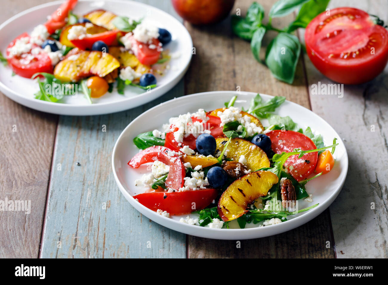 Grilled peach and heritage tomato salad Stock Photo - Alamy