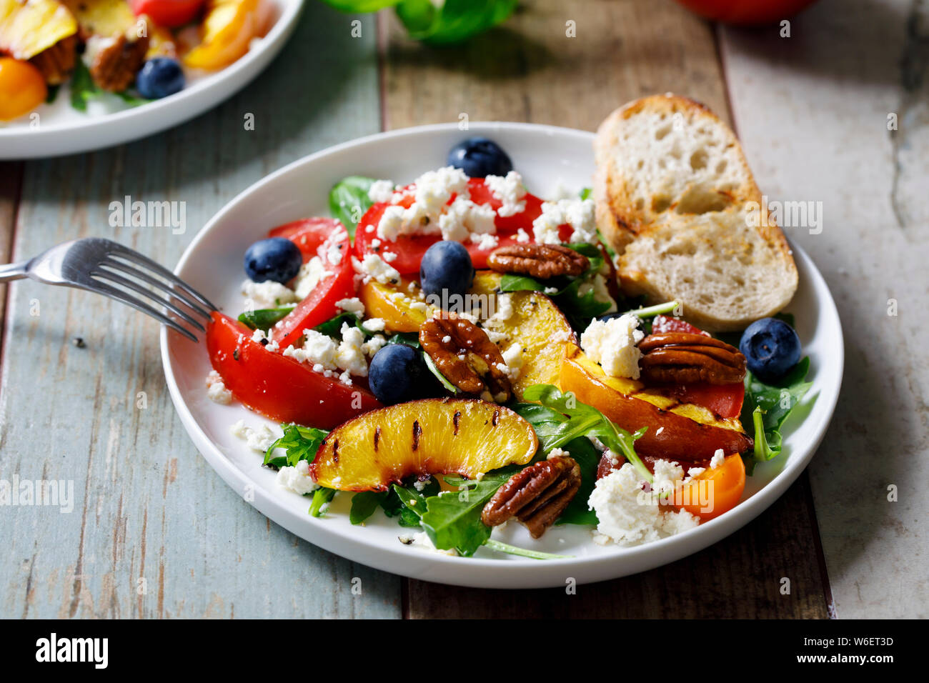 Grilled peach and heritage tomato salad Stock Photo - Alamy