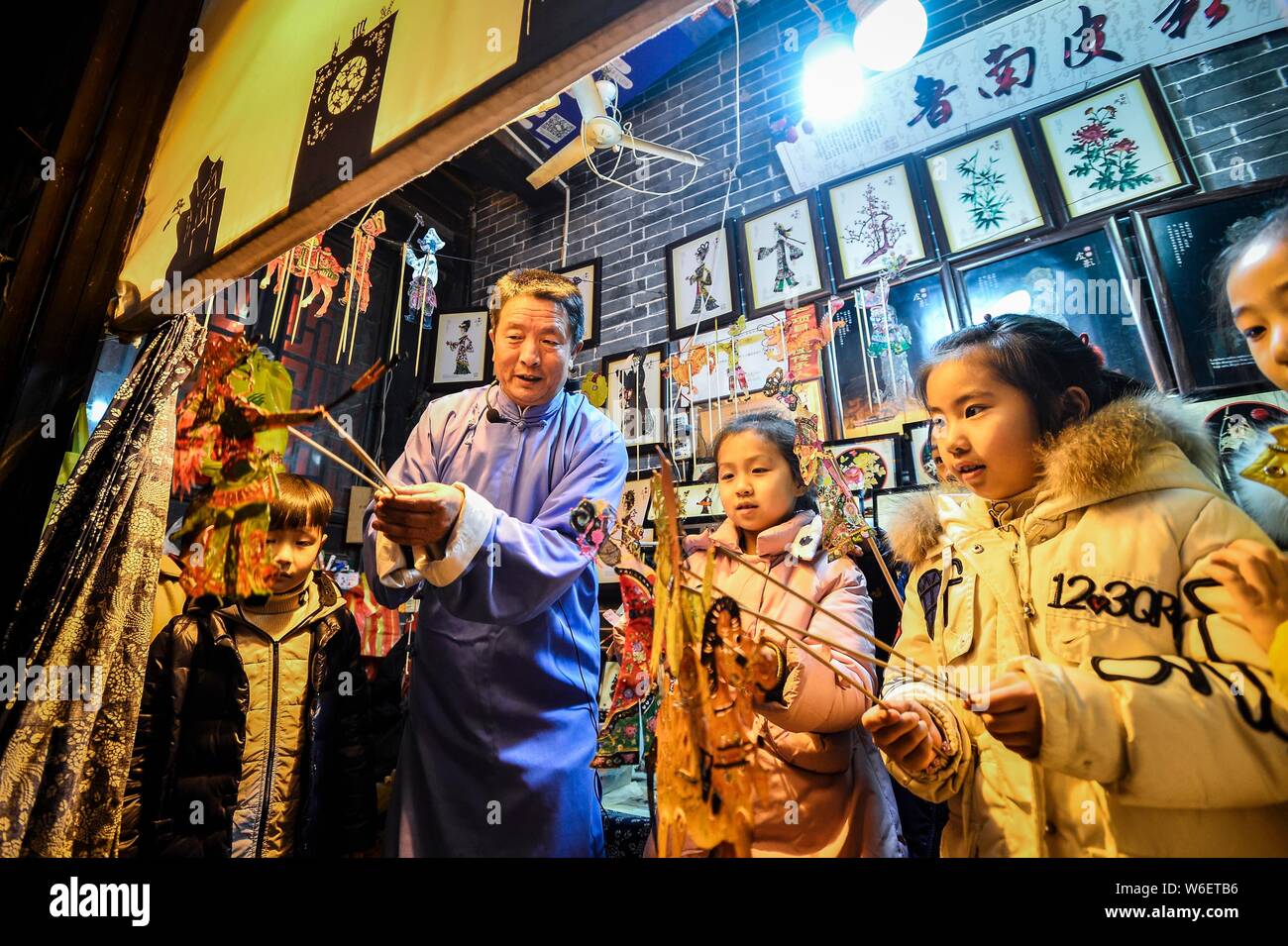 60-year-old Chinese folk artist Chen Shouke teaches children to perform shadow play or shadow puppetry, also known as shadow puppet, in Tai'erzhuang d Stock Photo