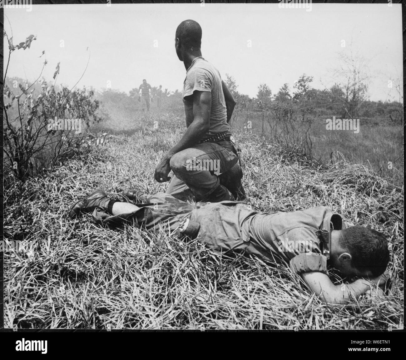 A young American lieutenant, his leg burned by an exploding Viet Cong white phosphorus booby trap, is treated by a medic., 1966; General notes:  Use War and Conflict Number 404 when ordering a reproduction or requesting information about this image. Stock Photo
