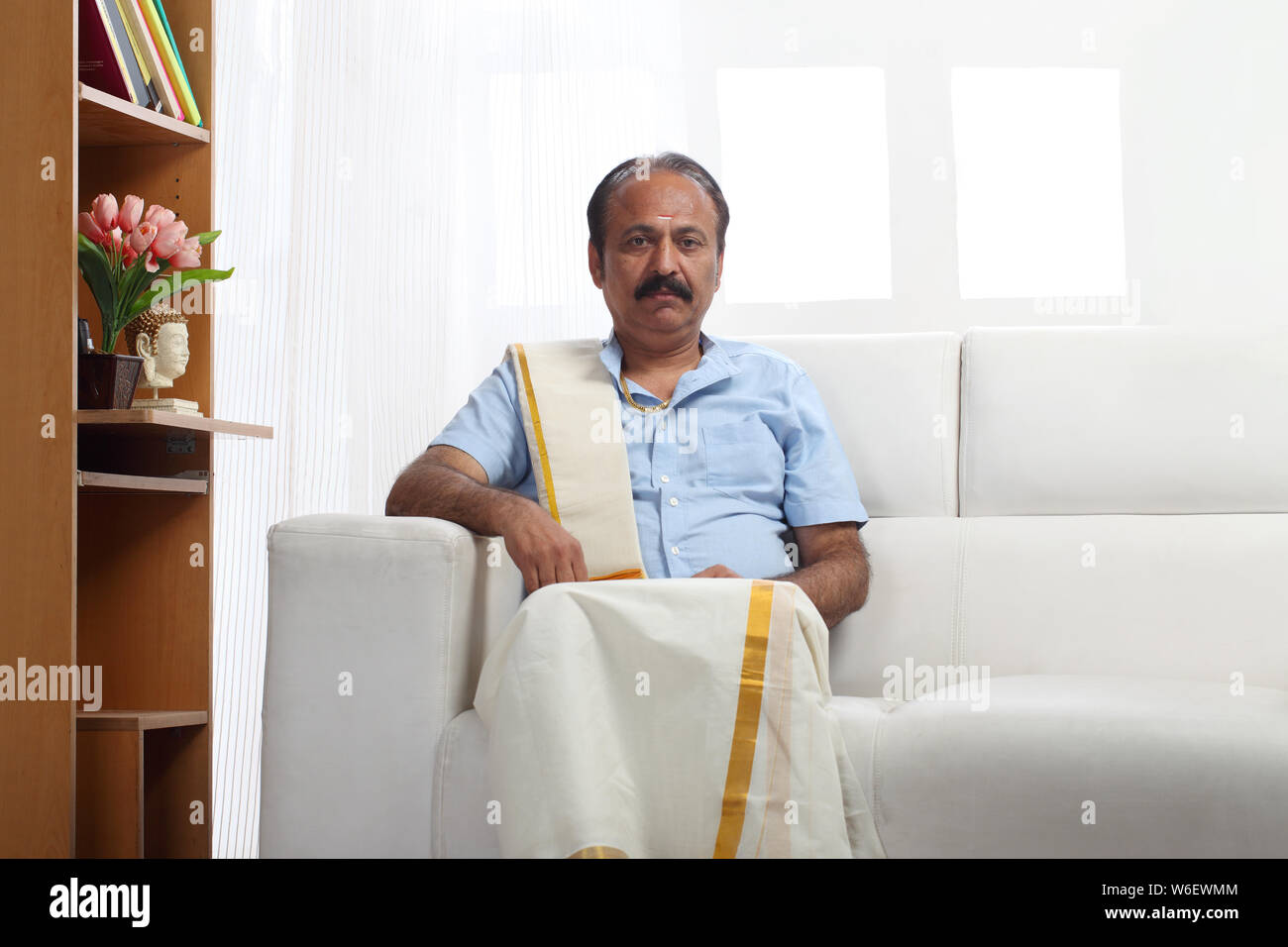 South indian man sitting on couch at home Stock Photo - Alamy