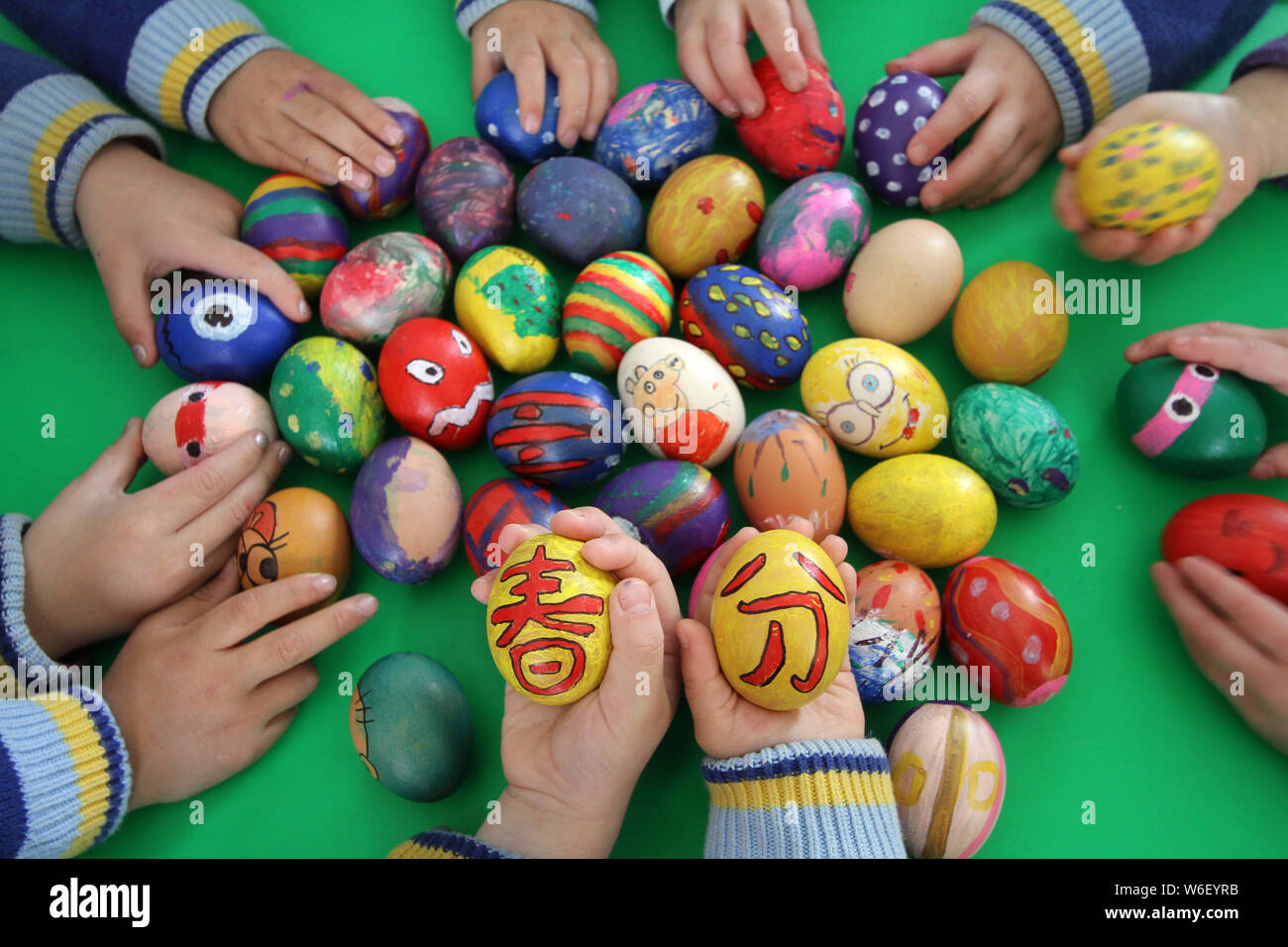 Children show eggs painted with Chinese characters and colors to mark the day of 'Chunfen' (Spring Equinox or Vernal Equinox) at a kindergarten in Han Stock Photo
