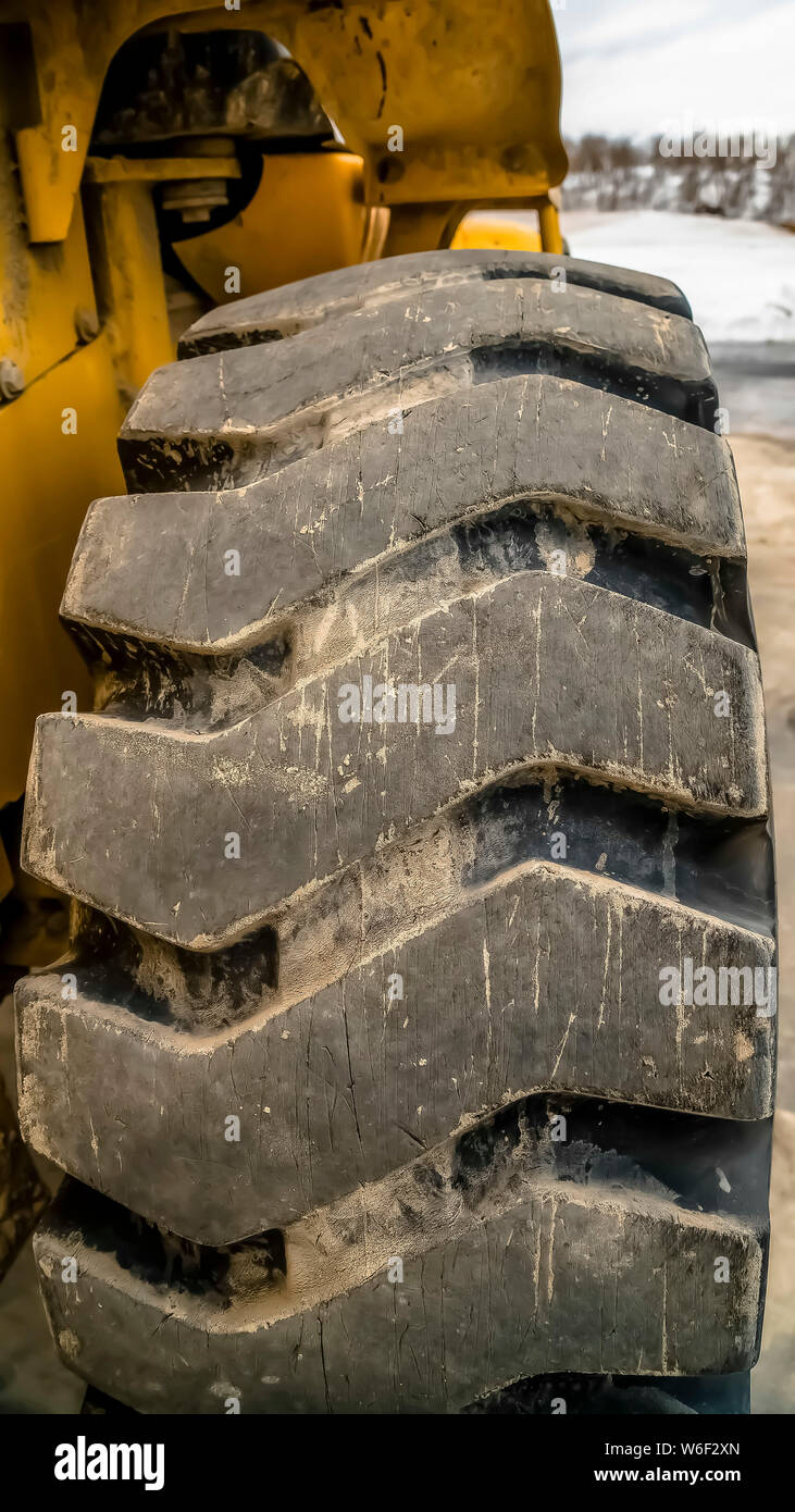 Vertical frame Close up of black rubber wheel with diagonal tread of a construction vehicle Stock Photo