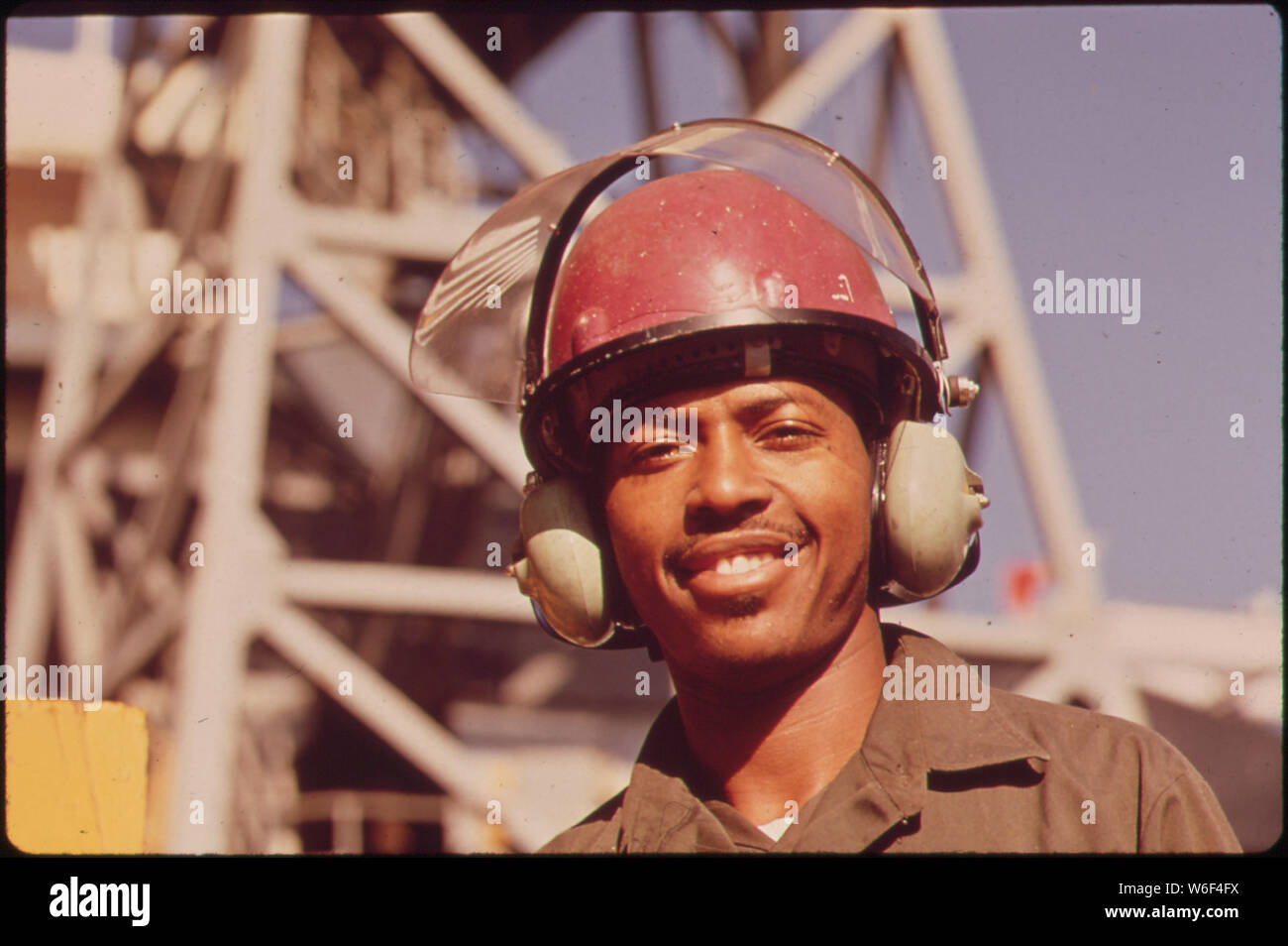 AVONDALE SHIPYARD WORKER WEARS SPECIAL EAR MUFFS FOR PROTECTION FROM