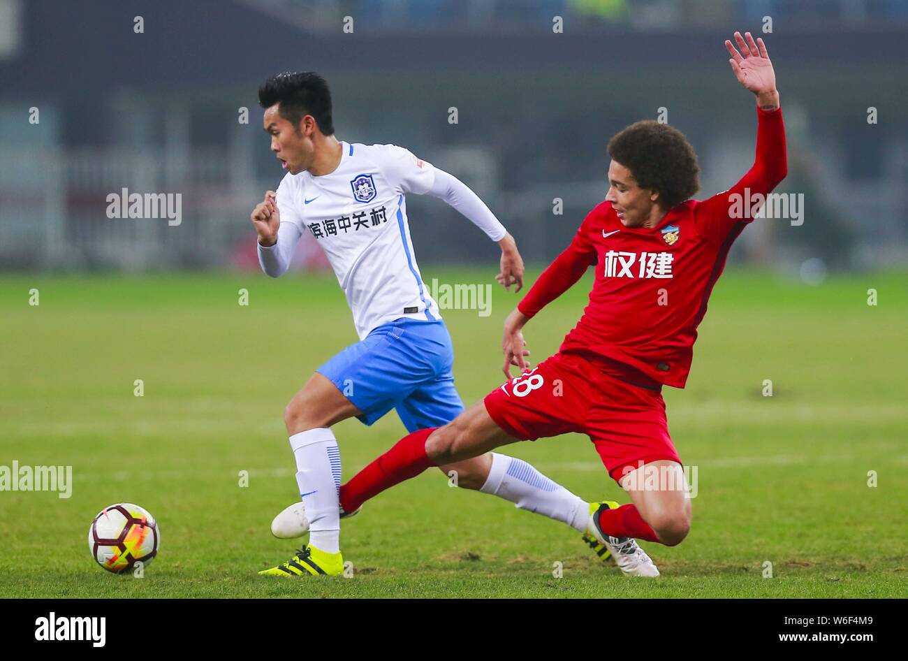 Belgian football player Axel Witsel, right, of Tianjin Quanjian challenges a player of Tianjin TEDA in their third round match during the 2018 Chinese Stock Photo