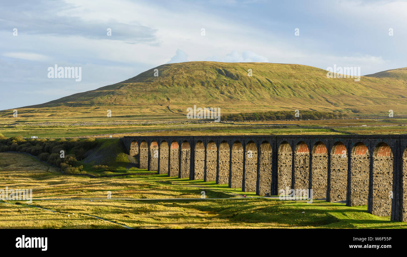 Evening sunlight & shadows on scenic countryside, arches of Ribblehead Viaduct & upland moors of Park Fell Hill - North Yorkshire Dales, England, UK. Stock Photo