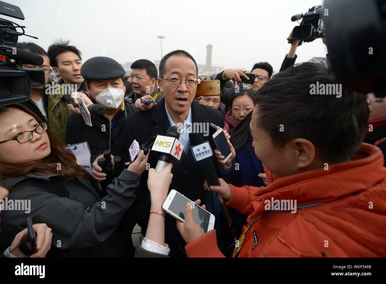 Michael Yu Minhong, founder and CEO of New Oriental Education & Technology Group, is surrounded by reporters as he arrives at the Great Hall of the Pe Stock Photo