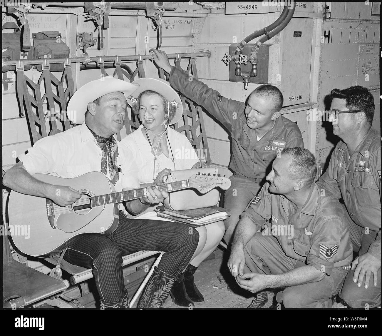 Air Borne Sing-A-Long. Roy and Dale Rogers entertain crew members of an Air Force C-123 Provider during the last leg of their Vietnam tour. Crew members are (left to right) Airman Second Class Cyril F. Crawly, 22, of Centerdale, RI, Staff Sergeant Francis K. Sutek, 35, of Fort Walton Beach, FL, and Technical Sergeant Eddie Miller, 36, of Rienzi, MS. Stock Photo