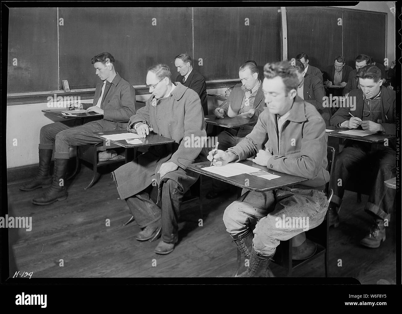 Applicants for skilled and unskilled laboring positions with the TVA being examined at High School building, Clinton, Tennessee. Mr. McDade, of TVA Division of Personnel, in charge. Stock Photo