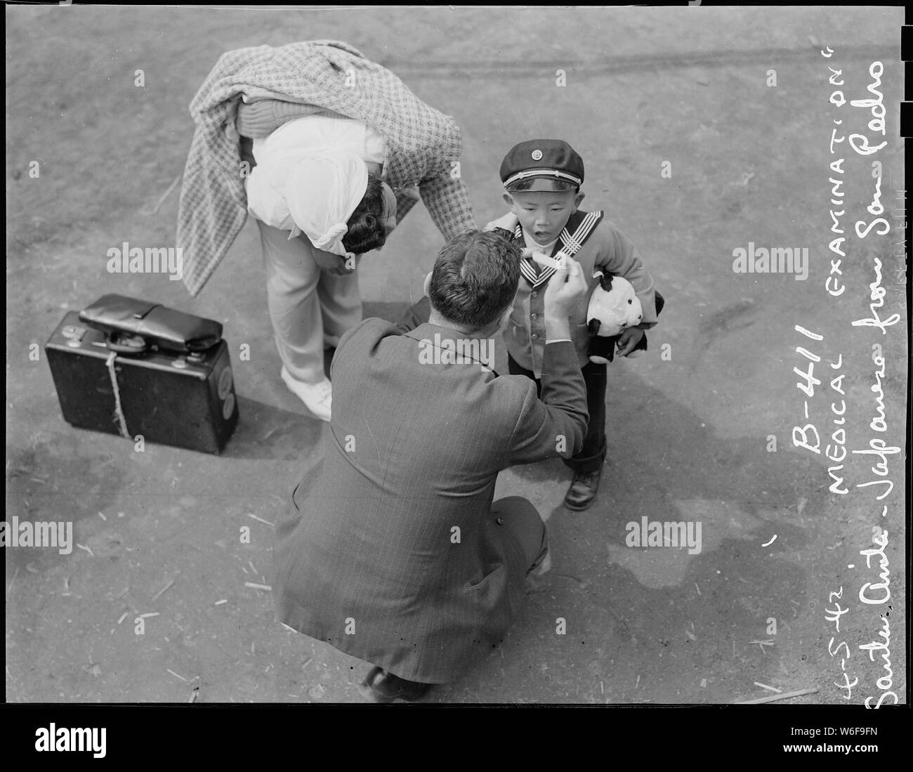 Arcadia, California. Preliminary medical examination for mother and son before entering Santa Anita . . .; Scope and content:  The full caption for this photograph reads: Arcadia, California. Preliminary medical examination for mother and son before entering Santa Anita assembly center for evacuees of Japanese ancestry. Evacuees are transferred later to War Relocation Authority centers for the duration. Stock Photo