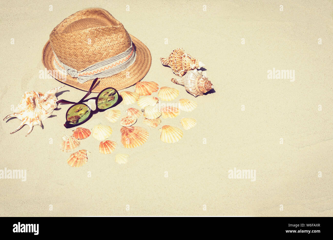 Vintage summer wicker straw beach hat and sun glasses on the sand with ...
