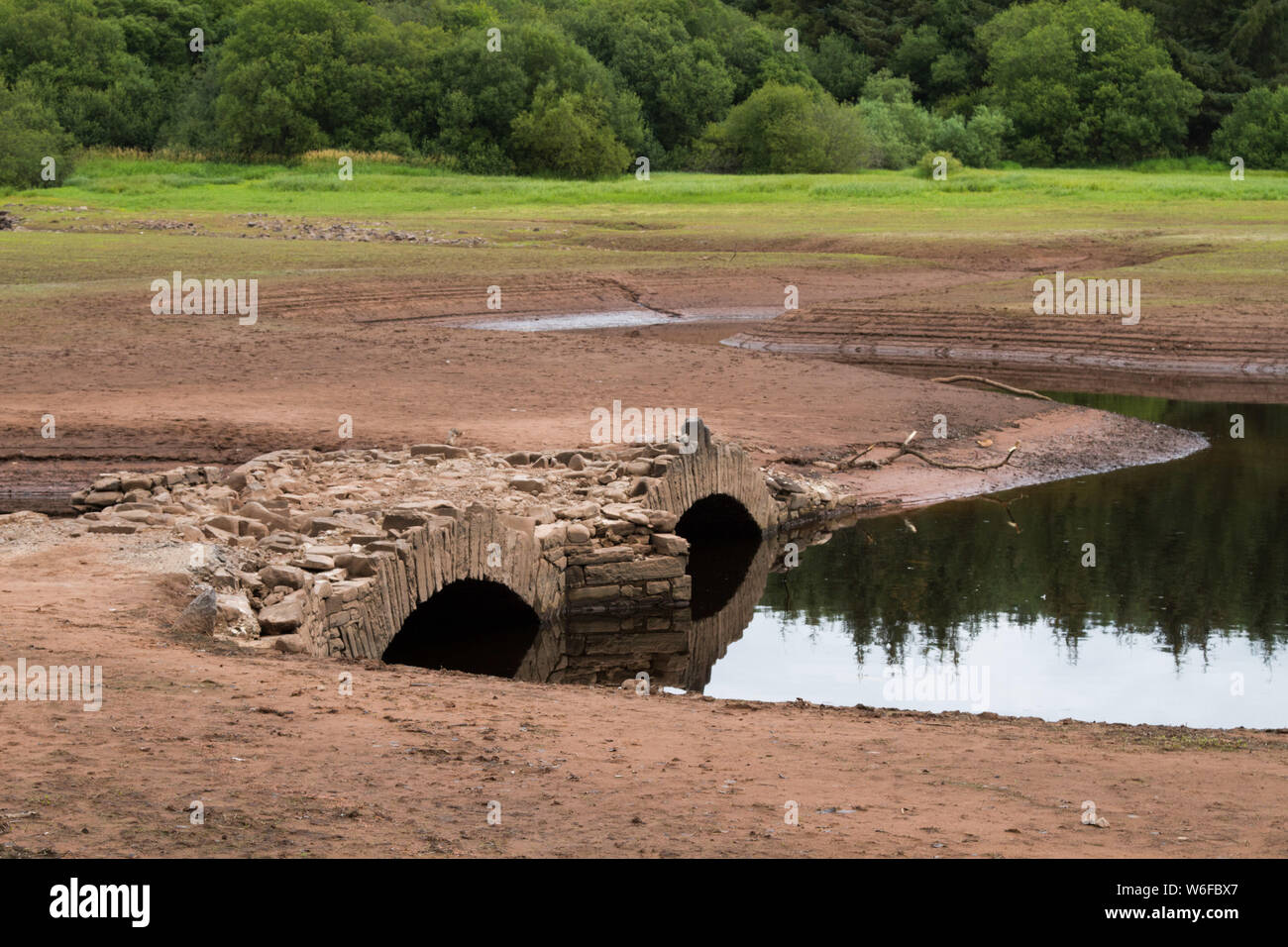 Llwyn On Reservoir, South Wales, UK. 1st Aug, 2019. UK weather: With the continued heatwave over recent weeks, the reservoir has depleted and uncovered an old bridge normally underwater, Pont Yr Daf. It was in use before the reservoir's construction. Credit: Andrew Bartlett/Alamy Live News Stock Photo