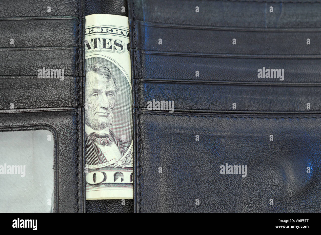 five dollar bill in wallet Stock Photo