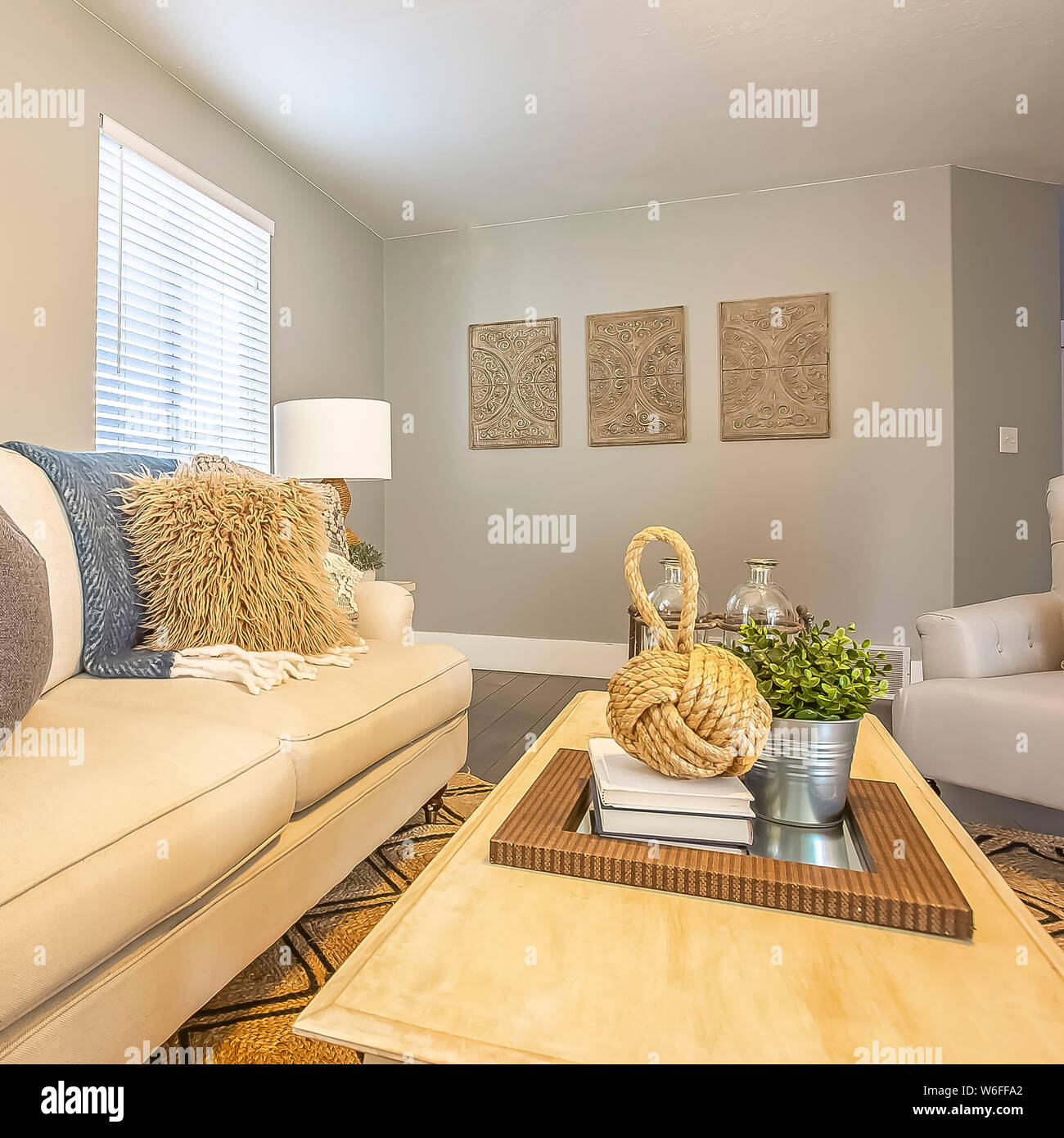 Square frame Beautiful living room with white sofa wood table fluffy  pillows and carpet Stock Photo - Alamy