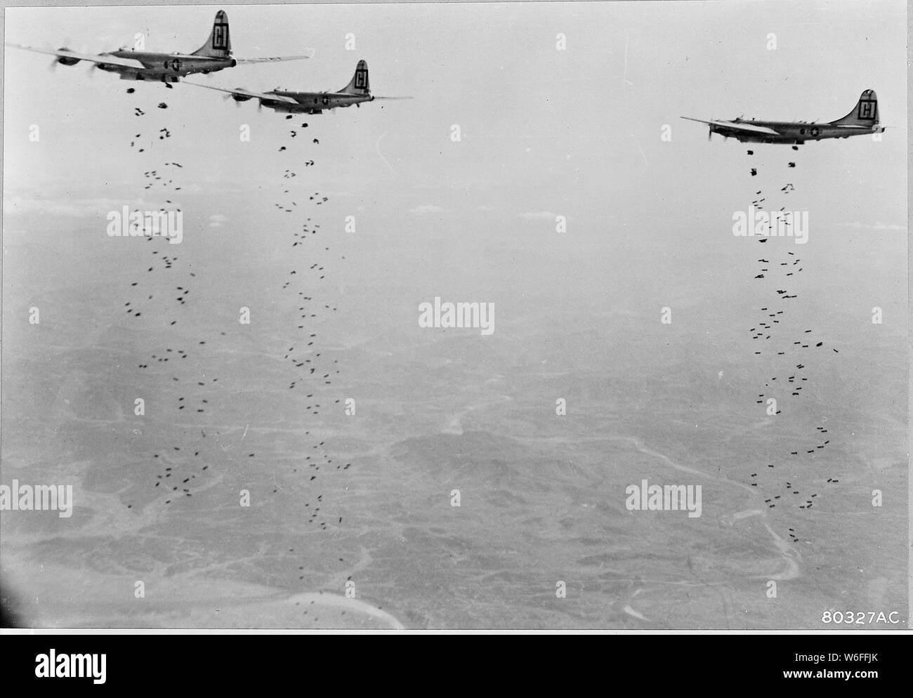 Bomber Command planes of the U.S. Far East Air Forces rain tons of bombs on a strategic military target of the Chinese Communists in North Korea. As part of the stepped-up aerial offensive against the enemy, attacks such as this are staggering the Reds, thus helping UN ground forces to stem the Communist push down the center of the Korean peninsula. The planes blasting the Red hordes are B-29 Superfort medium bombers. Stock Photo