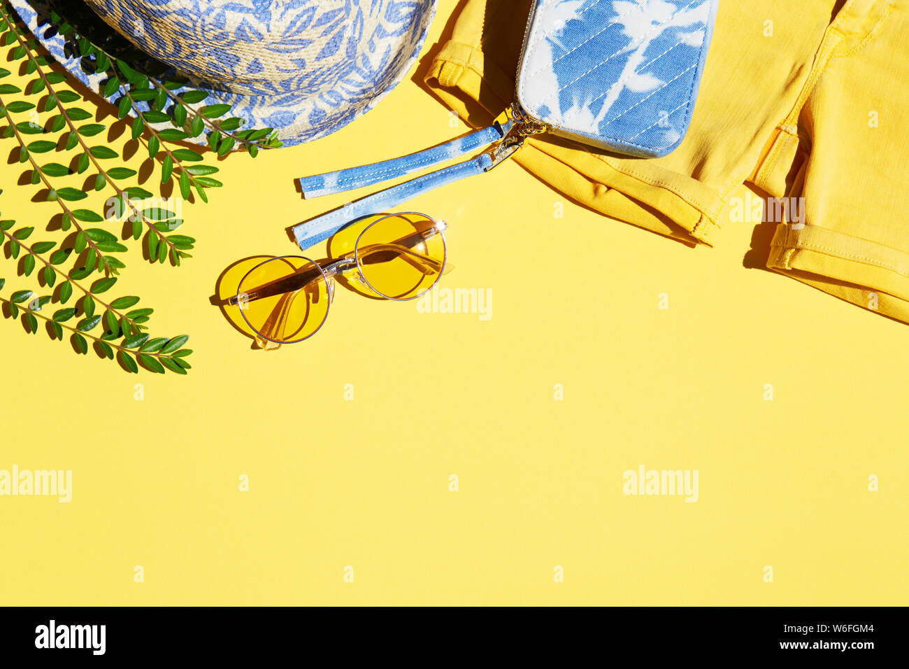 Woman summer beach fashion accessories and clothing items on yellow background Stock Photo