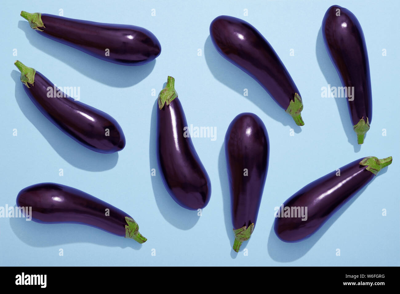 Aubergines on blue background, eggplant flat lay Stock Photo