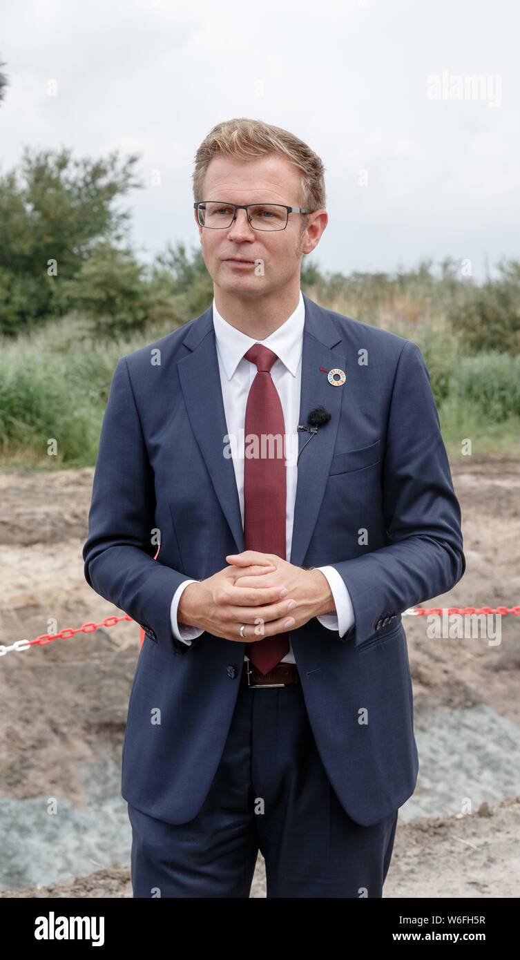 01 August 2019, Denmark, Rødbyhavn: Benny Engelbrecht (l), Minister of Transport of Denmark, is standing on the construction site of the planned Fehmarnbelt tunnel. Photo: Markus Scholz/dpa Stock Photo