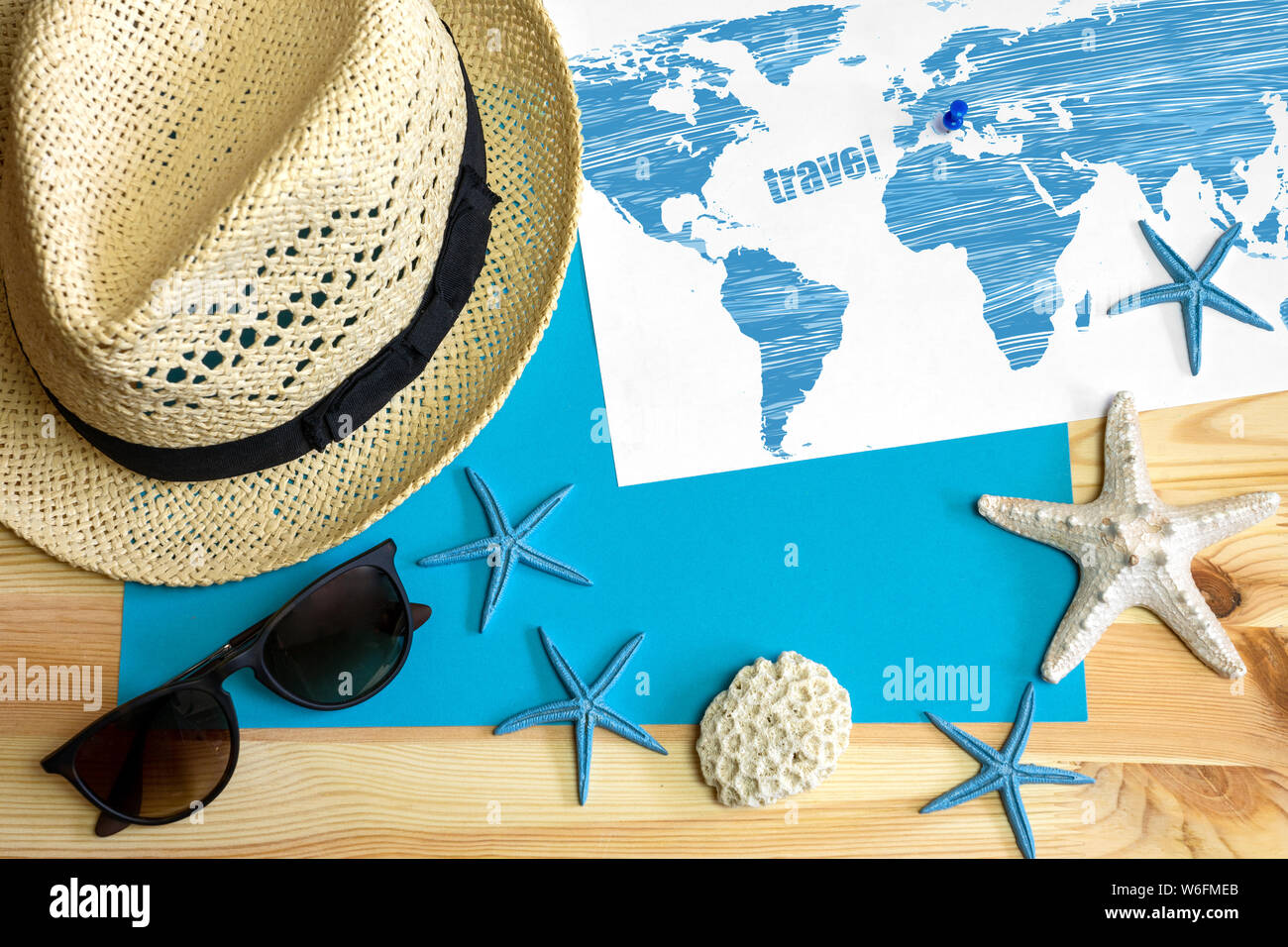 Go travel! Hat sunglasses and map with pin a on a wooden table. Top view Stock Photo